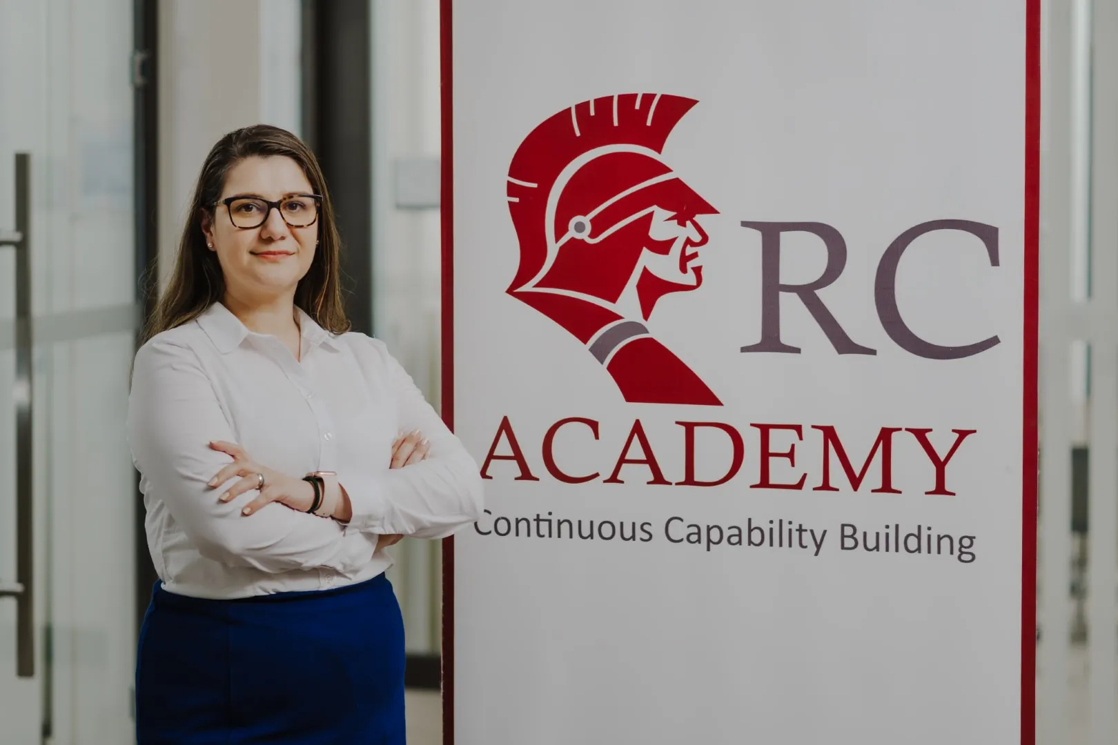 RC Academy eğitmeni, RC Academy logosunun önünde